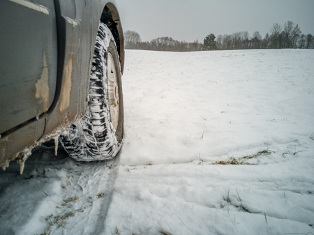 Empty Countryside Landscape in Cloudy Winter Day with Snow Partly Covering the Ground and Fog - Part of the Car in the Foreground - Concept of Travelingの写真素材