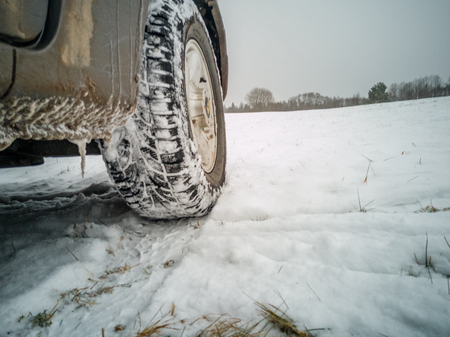 Empty Countryside Landscape in Cloudy Winter Day with Snow Partly Covering the Ground and Fog - Part of the Car in the Foreground - Concept of Travelingの写真素材