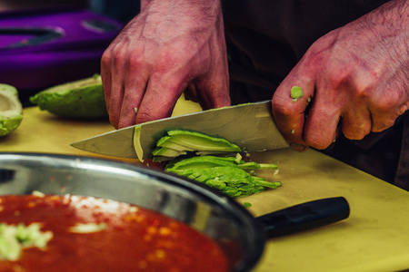 Male Chef Slicing Avocado for Wedding Meal - Kitchen Set with Isolated Action, Only Chef`s Hands, Vintage Film Lookの写真素材