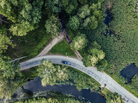 Drone Photo of Car Driving on the Road by the River under the Trees, Top Down View in Early Spring on Sunny Day - Concept of Peaceful Life in Countryside and Traveling, Freedom, Vintage Film Lookの写真素材