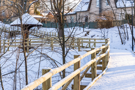 Snowy Photo of the Park on a Sunny Winter day - Wooden Footpath in the Middle of it, Concept of the Harmony and Travel in the Countrysideの写真素材