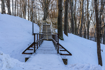 Snowy Photo of the Park on a Sunny Winter day - Wooden Footpath in the Middle of it, Concept of the Harmony and Travel in the Countrysideの写真素材