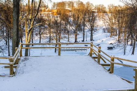 Snowy Photo of the Park on a Sunny Winter day - Wooden Footpath in the Middle of it, Concept of the Harmony and Travel in the Countrysideの写真素材