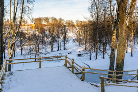 Snowy Photo of the Park on a Sunny Winter day - Wooden Footpath in the Middle of it, Concept of the Harmony and Travel in the Countrysideの写真素材
