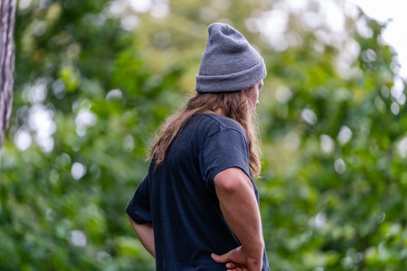 Photo of Hippy Millennial with Blue T-Shirt, Grey Hat and Long Hair Spending Some Quality Leisure...