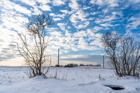Empty Countryside Landscape in Sunny Winter Day with Snow Covering the Ground with Power Lines in Frame, Abstract Background with Deep Look - Concept of Fun and Joyの写真素材