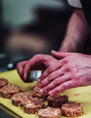 Male Chef Making Round Pork Cutlet for Some Burgers for Wedding Meal - Kitchen Set, Isolated Action with Chef`s Handsの写真素材