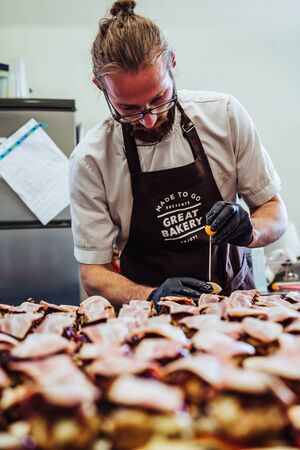 Odziena / Latvia - August 24th, 2018: Male Chef Putting Ingredients of Burgers in Black Gloves -...