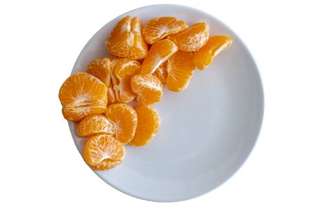 Top down view of pealed mandarin peaces on white plate on white background, copy space for textの写真素材