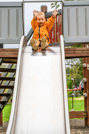 Nephew enjoys slide in the playgroundの写真素材