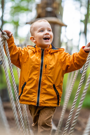 Cute Child Wearing Orange Raincoat Playing on Playground - Bright Autumn Dayの写真素材