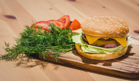 Chicken Burger with Fresh Tomatoes and Dills, set on Wooden Board with Copy Space on Topの写真素材