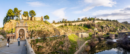 Toledo / Spain - January 23rd, 2020 Panoramic View, Tourists Walking over Alcantara Bridge on Sunny Dayのeditorial素材
