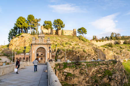 Toledo / Spain - January 23rd, 2020 Tourists Walking over Alcantara Bridge on Sunny Dayのeditorial素材