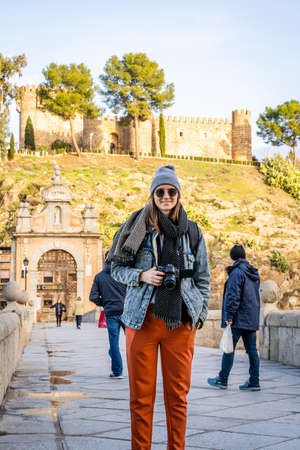 Toledo / Spain - January 23rd, 2020 Happy Solo Traveler Posing for a Photo on Alcantara Bridgeのeditorial素材