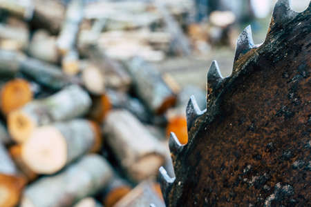 Out of Focus Pile of Logs and Saw - Abstract Concept of Spring Chores with Copy Spaceの写真素材