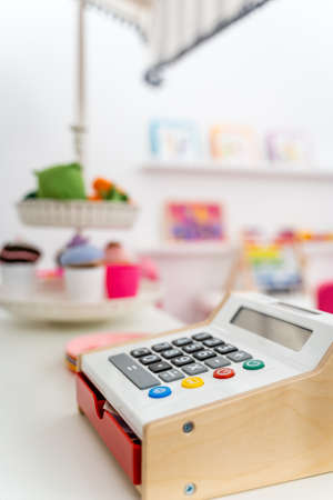 Toy Calculator Close Up with Child's Bedroom Blurred Background. Colorful Plates on Desk. Small Business Concept with Copy Spaceの写真素材