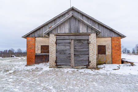 Old Wooden Shed Doors Exterior on White Brick Wall in Winterの写真素材