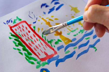 Hand with brush painting random strokes of Chinese ink.