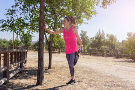Young woman stretching after running while listening to music with headphones. Healthy lifestyle....
