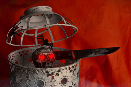 Open bird cage with skull inside and knife. Halloween banner. Selective focus. Copy space.の写真素材