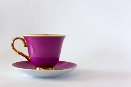 Pink tea or coffee cup with gold trim on white background. Selective focus. Copy space.の写真素材