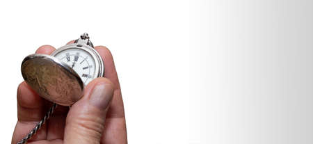 Man's hand holding a vintage pocket watch. Concept of time and work. Copy space. Isolated on white...