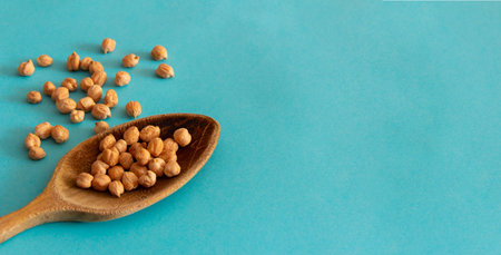 Wooden spoon with chickpeas on blue background. Top view. Flat lay. Copy space. Mediterranean food.の写真素材