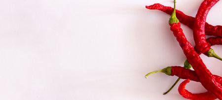 Thin red peppers on white background. Top view. Flat lay. Copy space.