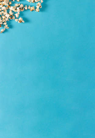 Popcorn on blue background. Flat lay. Copy space. Movie time.