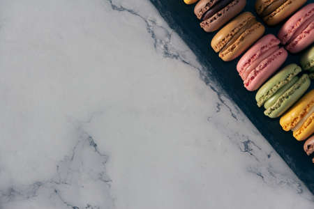 French macarons cookies in pastel colors on slate tray. Copy space. Selective focus.の写真素材