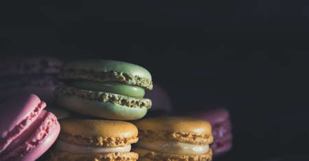 Gourmet dessert of French macarons on dark background. Copy space. Selective focus.の写真素材