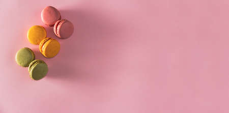 French pastel colored macarons dessert on pink background. Copy space. Selective focus.の写真素材