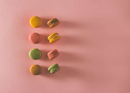 French pastel colored macarons dessert on pink background. Copy space. Selective focus.の写真素材