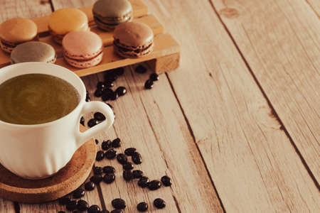 French macarons dessert with coffee cup and coffee beans. Copy space. Selective focus.の写真素材