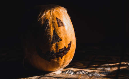 Pumpkin painted with spider web. Halloween decoration. Selective focus. Copy space.の写真素材