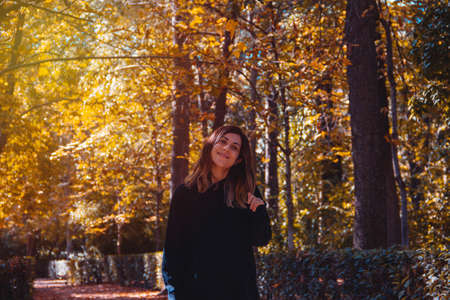 Portrait of young woman smiling in a park in autumn. Selective focus.