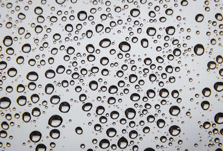 Highly contrasted raindrop background. Selective focus.