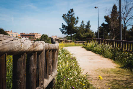 Urban park with dirt road and wooden fences with buildings in the background. Copyspace. Selective focus.の写真素材
