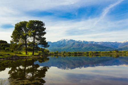 Almanzor peak, in the Gredos mountain, reflected in the water of a lake on a sunny day. Copyspace. Selective focus.の写真素材