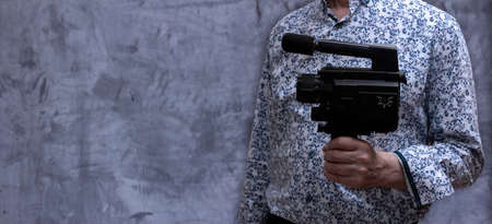 Man holding old vintage 8mm video camera. Copyspace. Selective focus.