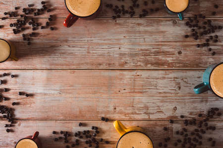 Colorful coffee cups with coffee beans on vintage wooden surface. Copy space. Selective focus.の写真素材