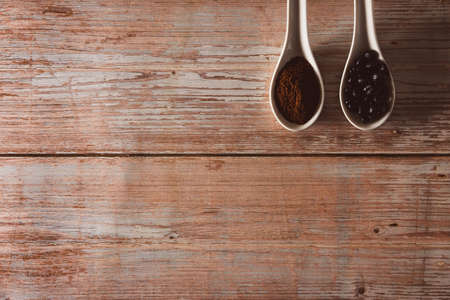 Spoons with coffee beans and ground coffee on vintage wooden surface. Copyspace. Selective focus.の写真素材