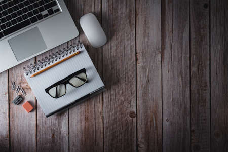 Workspace with laptop, notebook and glasses on wooden background. Topview. Copy space. Selective...