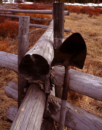 Old shovel leans against an even older fenceの写真素材