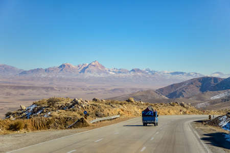 A blue car driving on a scenic road in Iranの写真素材