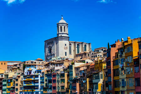 Girona, Spain - July 28, 2019: Colorful houses with balconies at the Jewish quarter of Girona, Catalonia, Spain, with Saint Mary cathedral overlooking the areaのeditorial素材