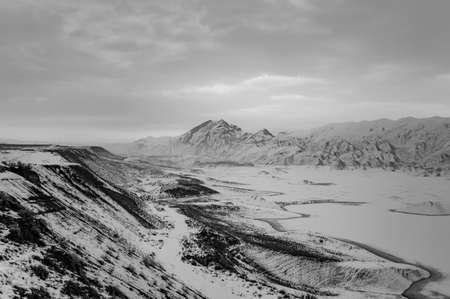 Black and white photo of a winter landscape in Armenia with Azat reservoir and Yeranos mountain rangeの写真素材