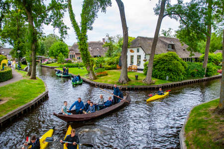 Giethoorn, Netherlands - July 6, 2019: Tourist groups on boats traveling through the canals of the village of Giethoorn in the Netherlandsのeditorial素材