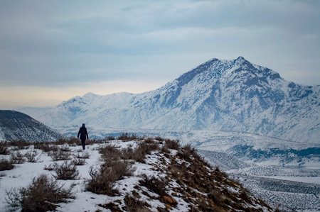 Unidentified person hiking along the bank of Azat reservoir in Armenia, with Mount Yeranos in the backgroundの写真素材
